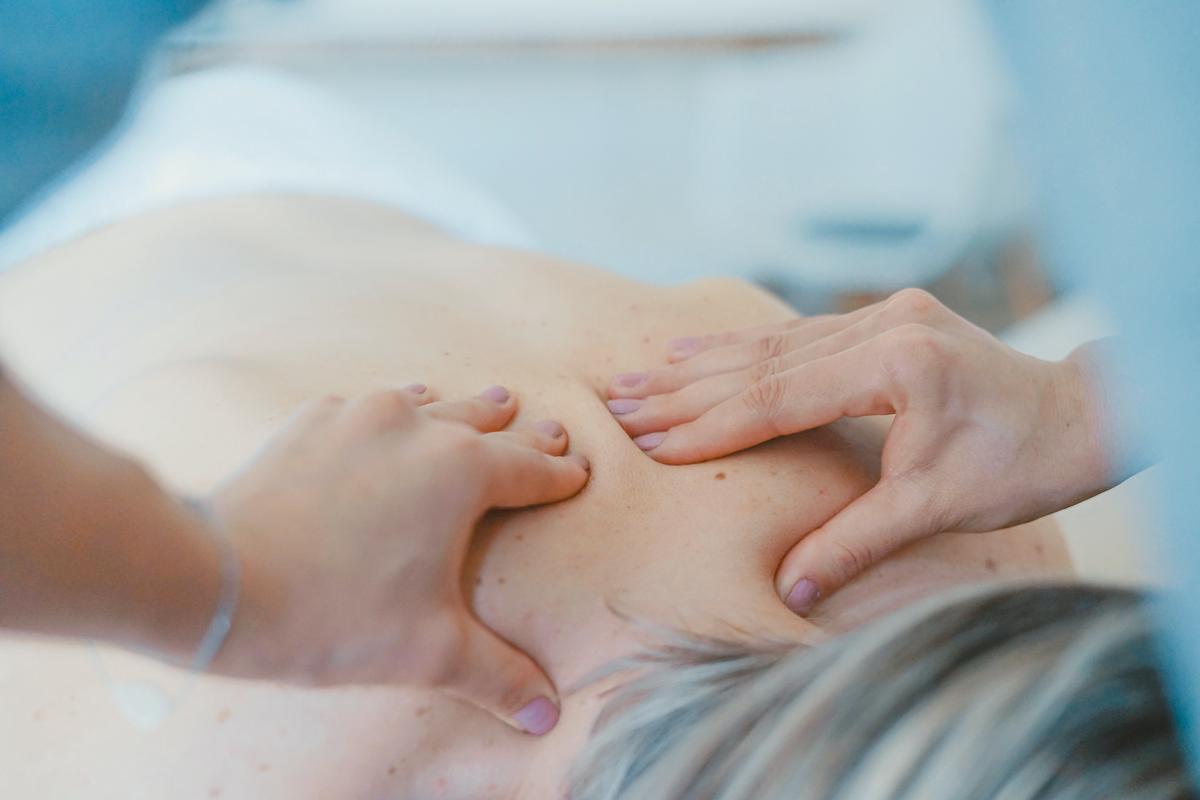 Image description: A person receiving a chiropractic massage treatment, with a therapist applying pressure on their back to manipulate the spine.